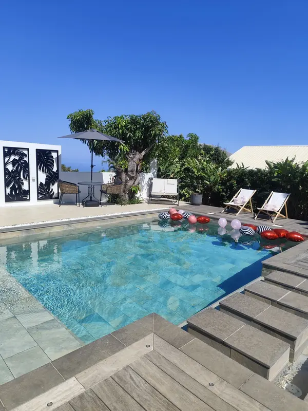 Piscine ensoleillée et terrasse du jardin
